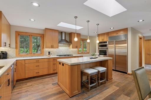 Warm wood floors, high-end appliances, and an abundance of cabinets and drawers for storage