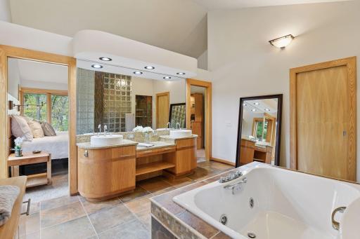 The spacious primary bath offers dual sink areas and unique design elements
