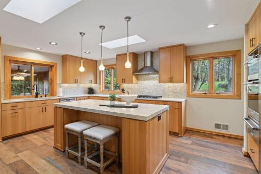 The kitchen offers a wonderful design flair with its clean lines, sleek tile backsplash, and beautiful natural light