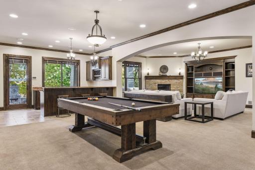 The walkout lower level showcases the family room with fireplace, full bar, billiards area, guest bedroom, exercise room, and a 20x36 indoor sport court with a full sheet of synthetic ice.