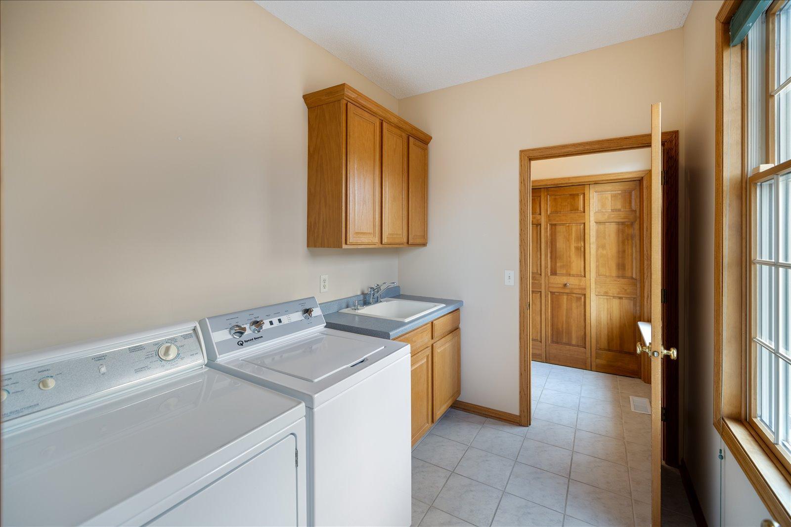 Laundry with built in cabinetry and utility sink