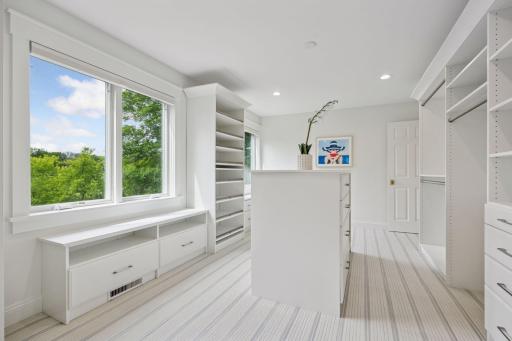 Luxury Closet with window, and custom cabinetry, convenient center unit.