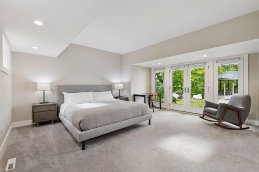 Tucked away on the main level is the Primary Suite which enjoys glass doors that lead out to the deck.