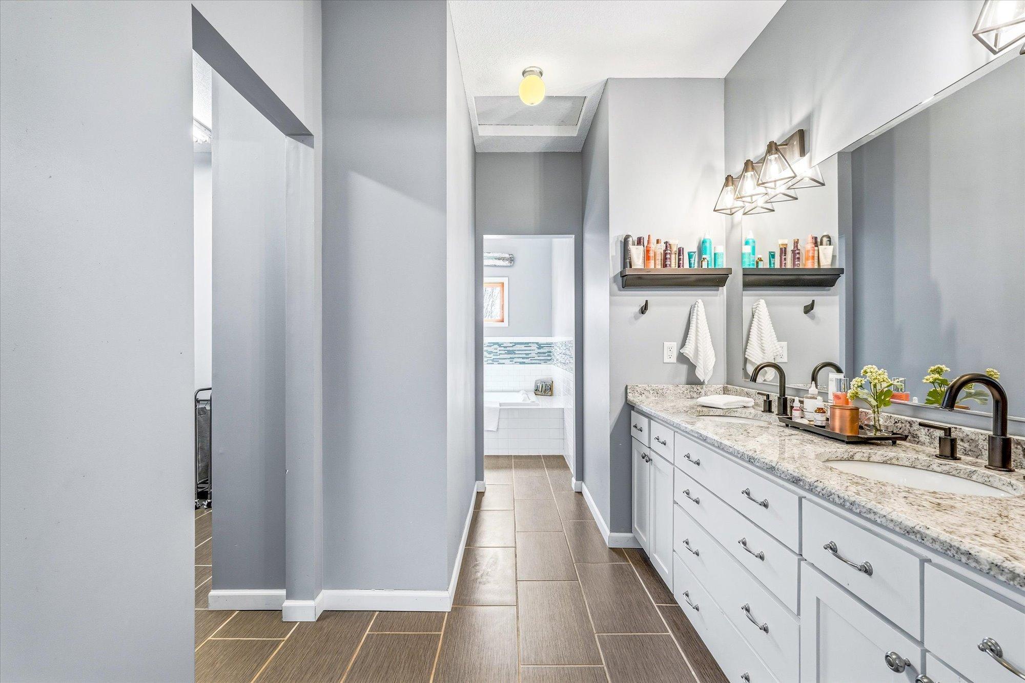 The private primary bath boasts double sinks, a soaking tub and a tiled walk-in shower.