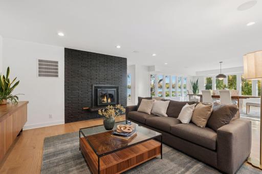 A striking brick fireplace adds dramatic contrast to this light-filled living room.