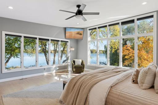 Expansive windows capture panoramic views of Gilfillan Lake from the primary suite.