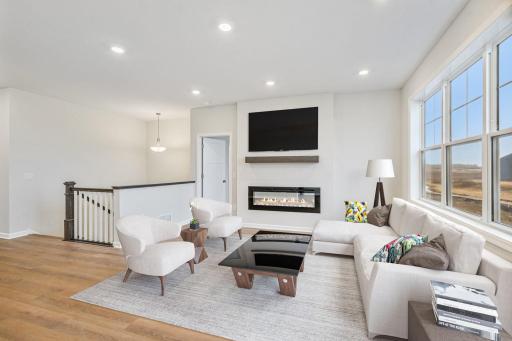 Light and Bright Family Room features a [icture window and cozy fireplace- virutal staging of similar home