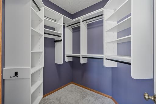 Primary suite closet has custom shelving.