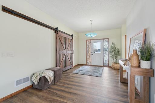 Sliding barn door provides access to guest coat closet.