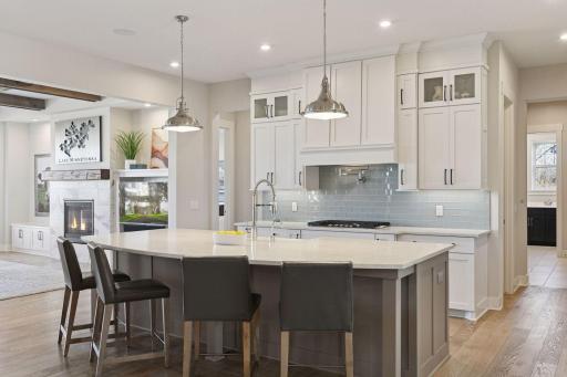 The gourmet kitchen features a large center island, quartz countertops, walk-in pantry, and professional-grade stainless steel appliances.