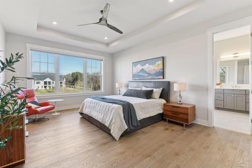 The primary bedroom suite showcases a spa-inspired bathroom with soaking tub, walk-in shower, dual vanities, and spacious walk-in closet.