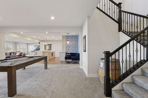 The walkout lower level offers a family room, wet bar with custom cabinetry, game area, exercise room, guest bedroom, and bathroom.