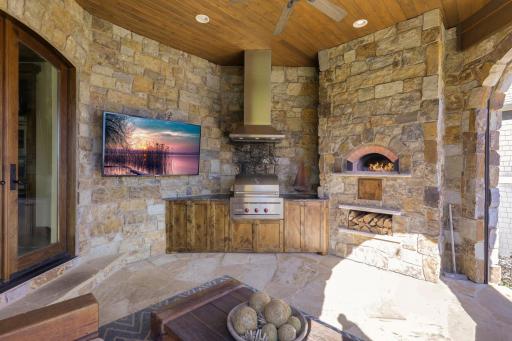 Possibly the most utilized room in the home, the California room, positioned next to the kitchen, offers a wood-fired pizza oven, a built-in gas grill, an outdoor TV, and motorized Phantom screens.