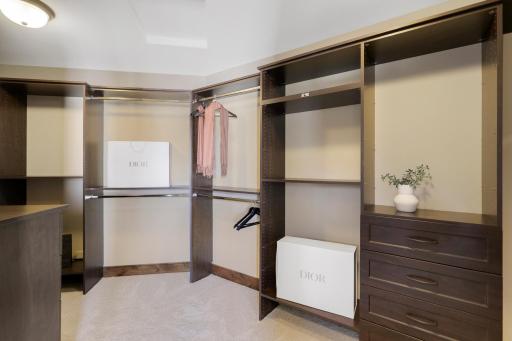 Retire to the luxurious primary ensuite with panoramic lake views, vaulted ceilings, natural stone-topped vanity with dual sinks, a soaker tub, a walk-in shower with two shower heads, and a huge walk-in closet.