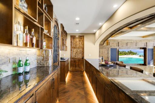 The walkout lower level is set for entertaining lake guests, boasting a fully equipped bar attached to the media room, a climate-controlled wine room, a tasting room, a 5th bedroom, additional storage, and a lake storage room with a 2nd laundry.