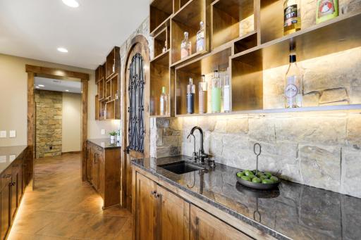 The walkout lower level is set for entertaining lake guests, boasting a fully equipped bar attached to the media room, a climate-controlled wine room, a tasting room, a 5th bedroom, additional storage, and a lake storage room with a 2nd laundry.