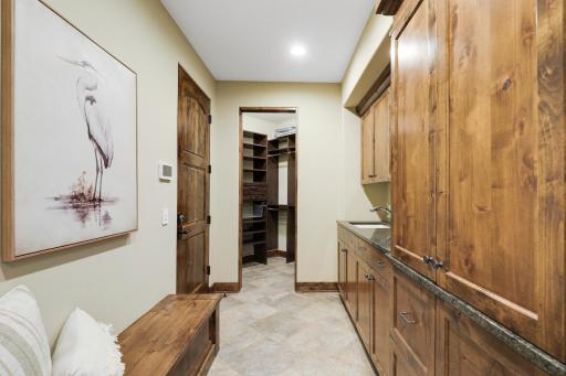 The mud room connects to the garage and kitchen, and features a large sink, plenty of cabinet storage and a large walk-in closet.