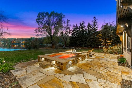 A generously sized, inground hot tub on the lower patio boasts decorative lighting and water features providing the perfect place to unwind after a long day on the lake.