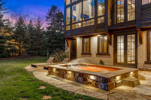 A generously sized, inground hot tub on the lower patio boasts decorative lighting and water features providing the perfect place to unwind after a long day on the lake.