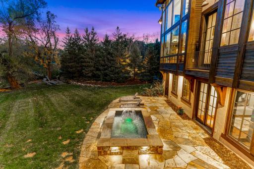 A generously sized, inground hot tub on the lower patio boasts decorative lighting and water features providing the perfect place to unwind after a long day on the lake.