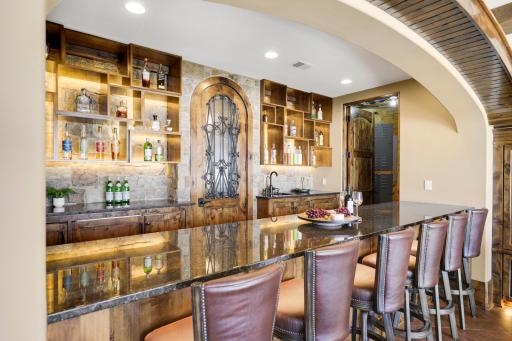 The walkout lower level is set for entertaining lake guests, boasting a fully equipped bar attached to the media room, a climate-controlled wine room, a tasting room, a 5th bedroom, additional storage, and a lake storage room with a 2nd laundry.