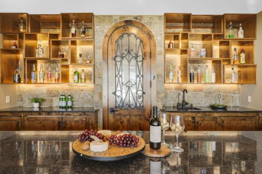 The walkout lower level is set for entertaining lake guests, boasting a fully equipped bar attached to the media room, a climate-controlled wine room, a tasting room, a 5th bedroom, additional storage, and a lake storage room with a 2nd laundry.