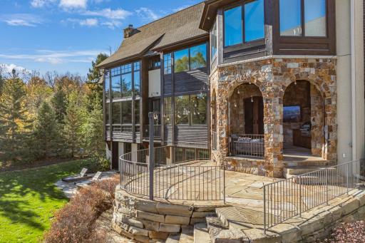 Natural stone retaining walls and strategically placed landscape lighting accentuate the architectural features of the home.