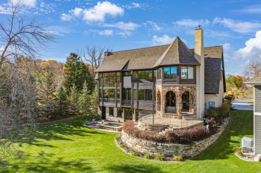 Natural stone retaining walls and strategically placed landscape lighting accentuate the architectural features of the home.