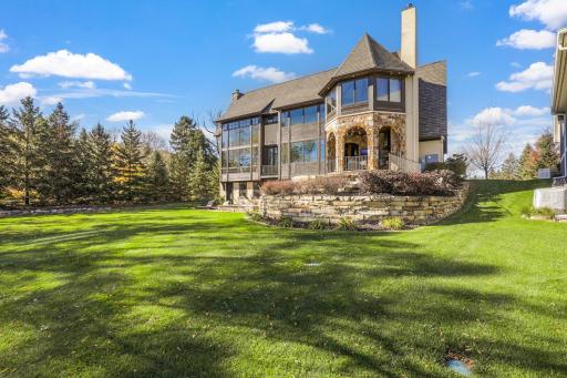 The almost perfectly flat backyard gently slopes to 133 feet of owned, southeast facing lakeshore on the crystal clear, A-rated waters of Smithtown Bay, Lake Minnetonka.