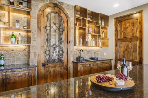 The walkout lower level is set for entertaining lake guests, boasting a fully equipped bar attached to the media room, a climate-controlled wine room, a tasting room, a 5th bedroom, additional storage, and a lake storage room with a 2nd laundry.