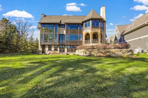 The almost perfectly flat backyard gently slopes to 133 feet of owned, southeast facing lakeshore on the crystal clear, A-rated waters of Smithtown Bay, Lake Minnetonka.