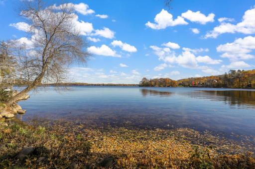The almost perfectly flat backyard gently slopes to 133 feet of owned, SE facing lakeshore on the crystal clear, A-rated waters of Smithtown Bay, Lake Minnetonka.