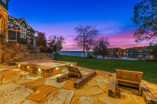 A generously sized, inground hot tub on the lower patio boasts decorative lighting and water features providing the perfect place to unwind after a long day on the lake.