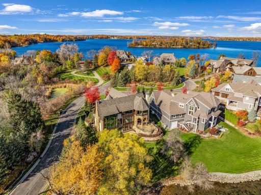 The almost perfectly flat backyard gently slopes to 133 feet of owned, southeast facing lakeshore on the crystal clear, A-rated waters of Smithtown Bay, Lake Minnetonka.