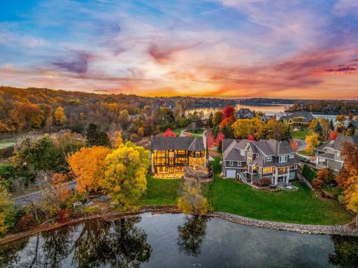 Natural stone retaining walls and strategically placed landscape lighting accentuate the architectural features of the home.