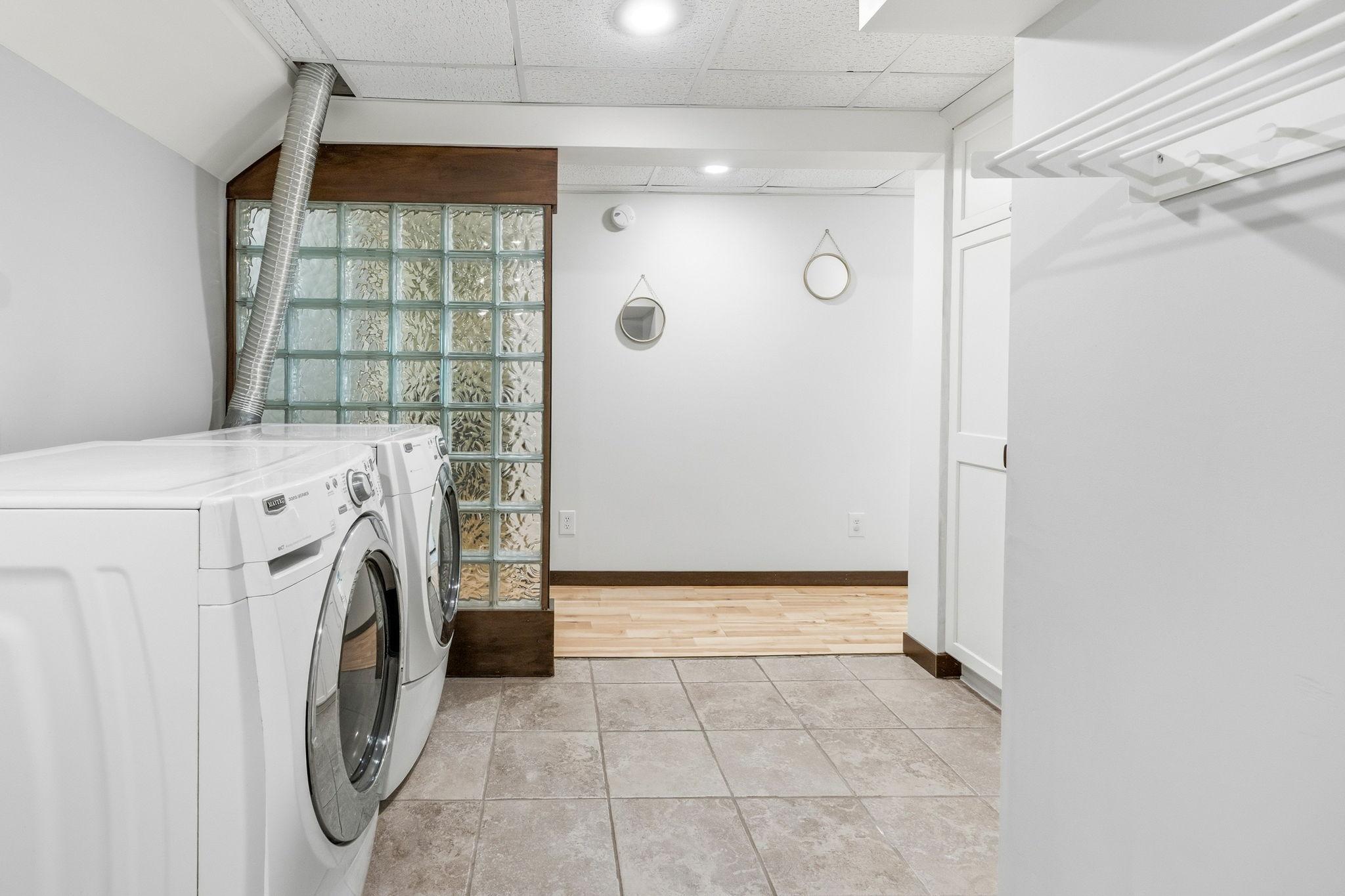 Convenient Laundry Room with lots of cupboards and a utility sink. And a storage area!