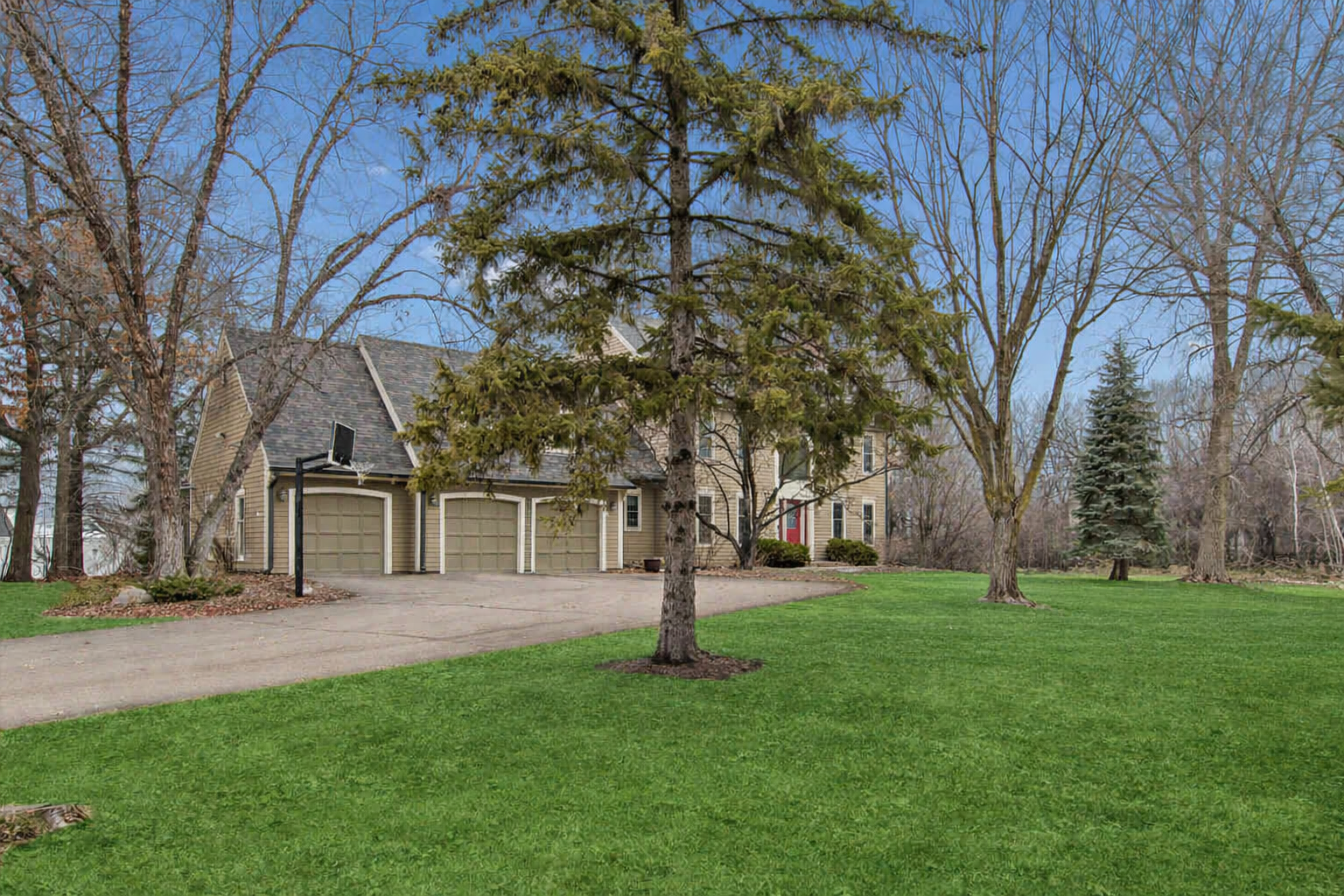 Large front yard with mature trees overlooking pond on nearly an acre