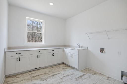 Situated in a discreet corner on the first floor, this large laundry room provides ample space to complete daily household chores and other organizational tasks.
