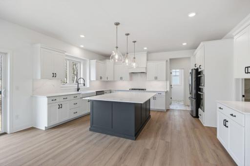 Melding seamlessly with a breakfast room for casual meals, the sunlit kitchen comes equipped with popular features and a spacious pantry that makes it equal parts functional and stylish.