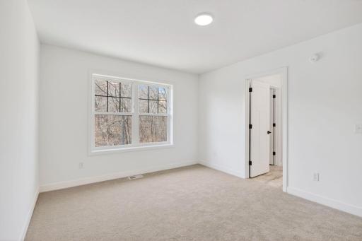This bedroom located on the second floor features an en-suite bathroom and a walk-in closet.