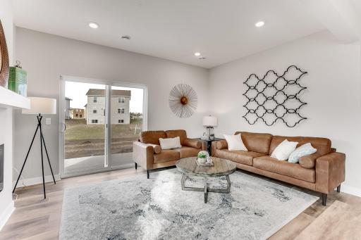 Great light and plenty of space in this living room! *Photo is of a model home. The home listed for sale is on a walkout basement, therefore will not have a patio outside of the sliding doors.