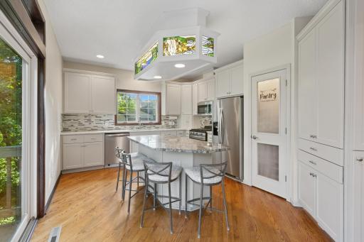 Photo for 13306 Huntington Circle, Saint Paul, MN 55124 - listing #6810726 Light and bright chef's kitchen features hardwood floors, updated custom cabinetry, tile backsplash, stone countertops, stainless steel appliances, walk-in pantry, and much more!