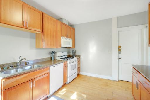 The updated kitchen features warm wood cabinetry with plenty of storage and prep space.