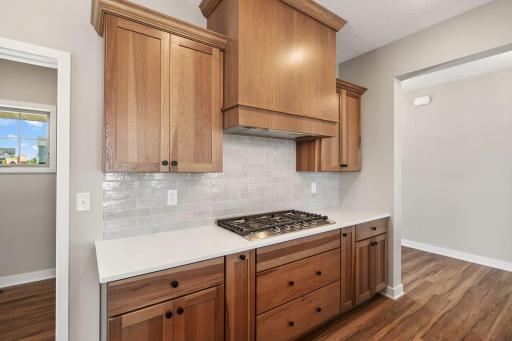 Gas cooktop with wood hood that is vented outside.