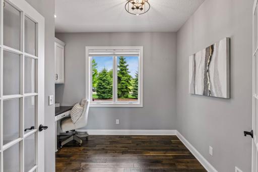 Front office space just off the kitchen and living room features double French doors and built in desk.