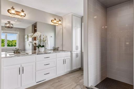 Primary bath features large soaking tub, tiled walk-in shower, dual vanities, and separate water closet