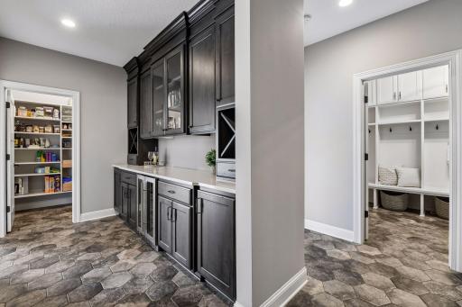 As you enter in from the garage you are greeted by walk in pantry, beverage station and mudroom to the right