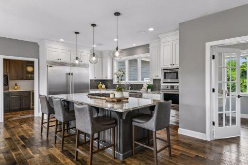 Kitchen is complete with custom cabinetry, fridgeaire professional appliance package, Cambria countertops, and an oversized center island with gas cooktop.