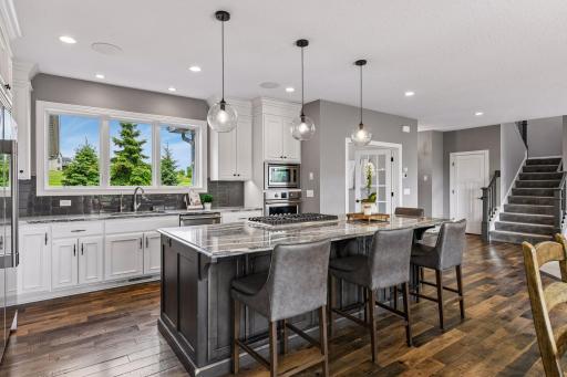 Kitchen is complete with custom cabinetry, fridgeaire professional appliance package, Cambria countertops, and an oversized center island with gas cooktop.