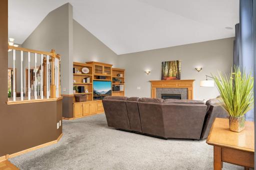 Living room provides a gas-burning fireplace and a wall of built-in cabinets.